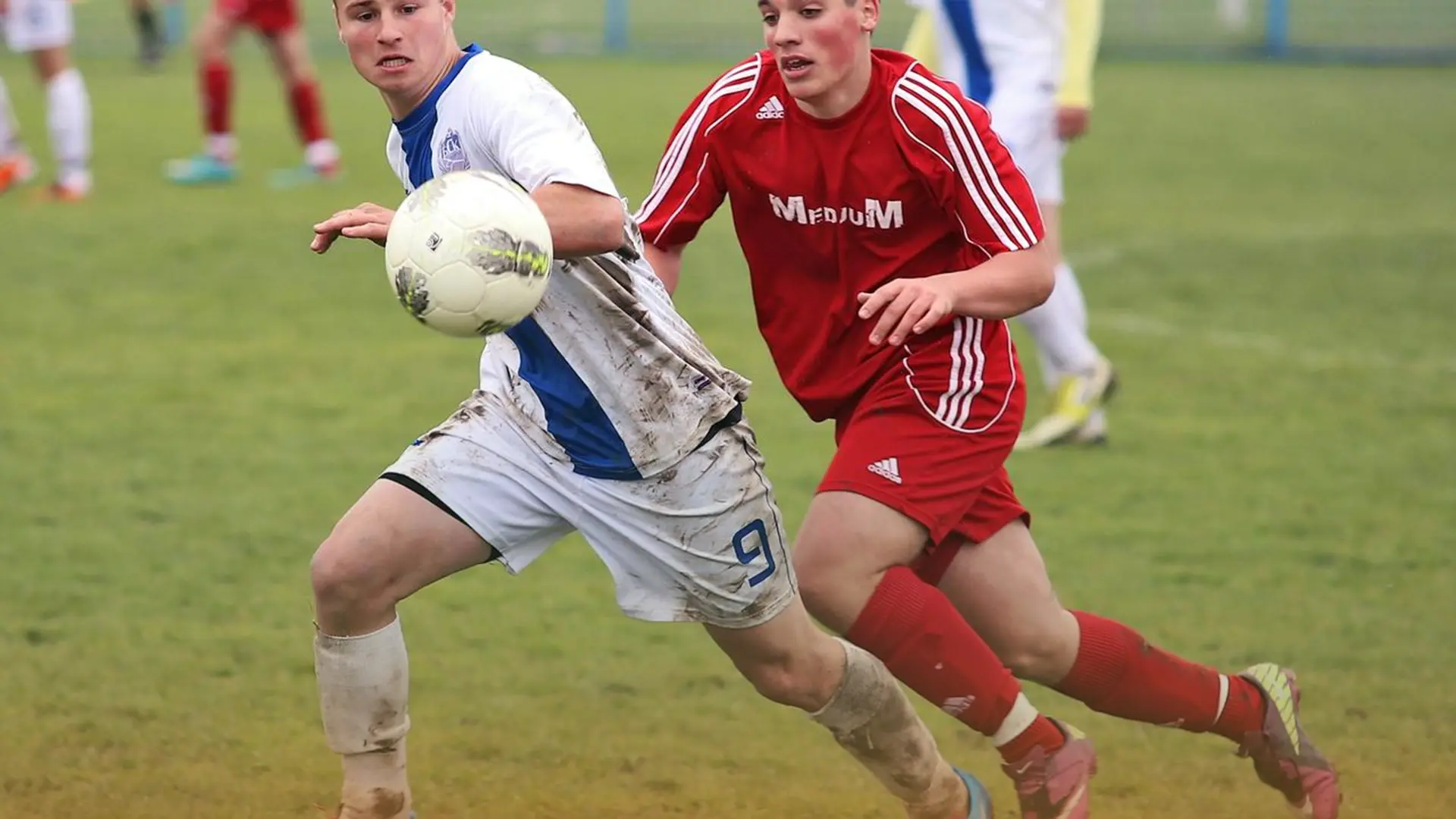 تصویر دو مرد ورزشکار بازیکن فوتبال که در حال بازی کردن هستند